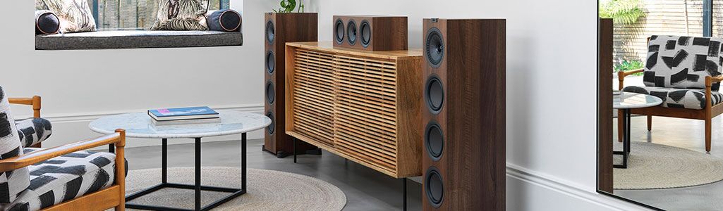 KEF Q550 floor speakers in the walnut color in a living room