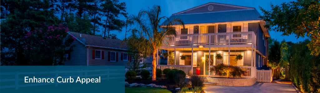 Dusk scene of house lit up with FL Luminaire lights with heading Enhance Curb Appeal