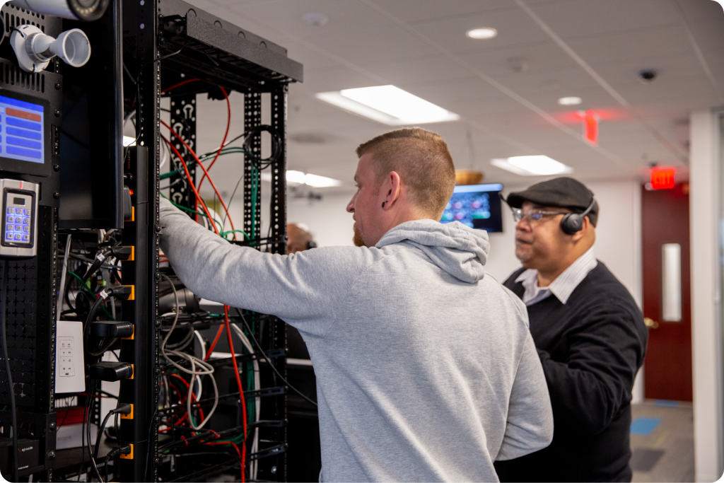 Tech support agents on phone in front of one of Snap One's av rack trouble shooting an error