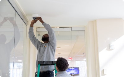 Installer placing a speaker in the ceiling of a home