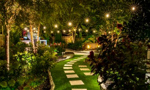 Outdoor pathway at night lit up with pergola