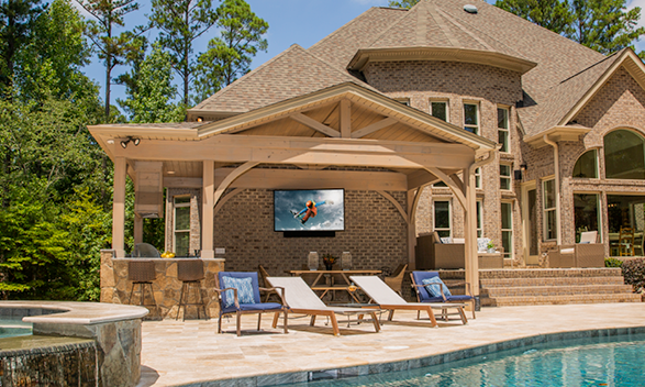 TV mounted on the back wall of a house by the pool