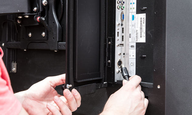 Man plugging in a cable into the back of a TV