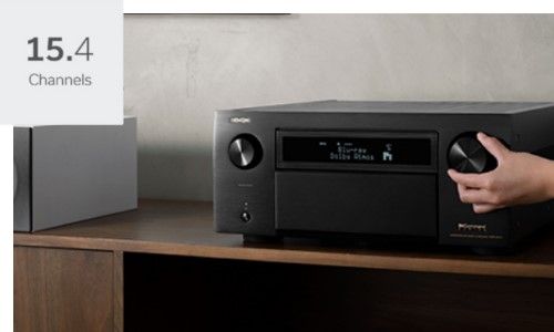 Someone turning the knob of the Denon AVR