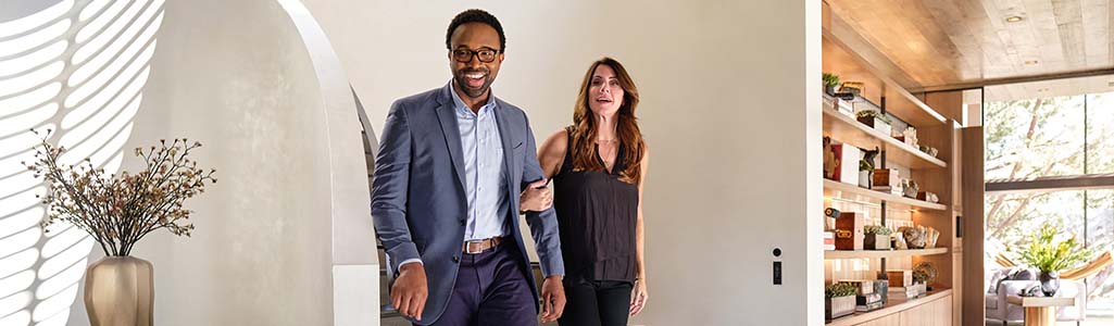 Man and woman coming down the stairs in their home