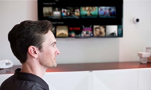 Smart TV on a wall displaying several streaming apps