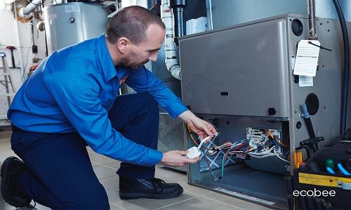 Installer working with wires of furnace for ecobee thermostat