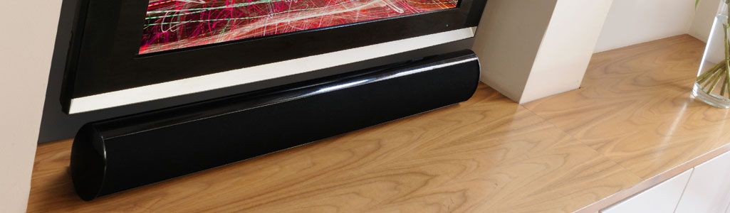 Angled view of soundbar below the TV on top of a cabinet