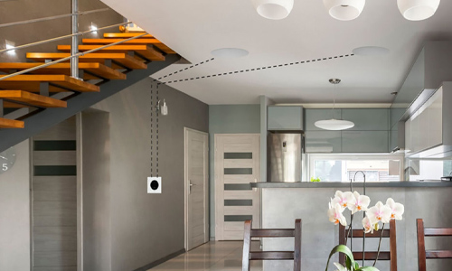 Amp installed in kitchen wall with dotted lines representing speaker wire