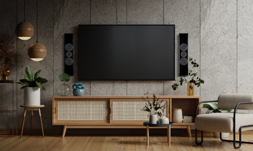 Flatscreen TV on a wall in a living room with the OWLCR flanking it.