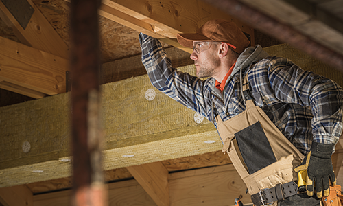 Installer in the rafters installing a speaker