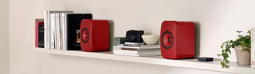 Red LSX KEF speakers on bookshelf