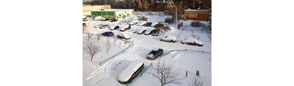 Snowy parking lot full of cars