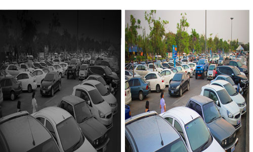 image of color in near-total darkness of a car lot at night 