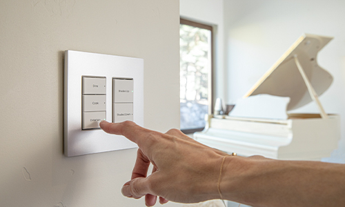 Person choosing lighting option on wall with piano in background