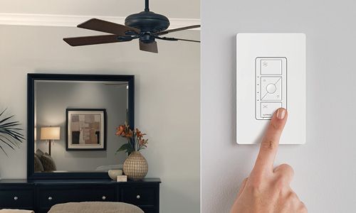 Home scene with ceiling fan and hand touching fan control on wall