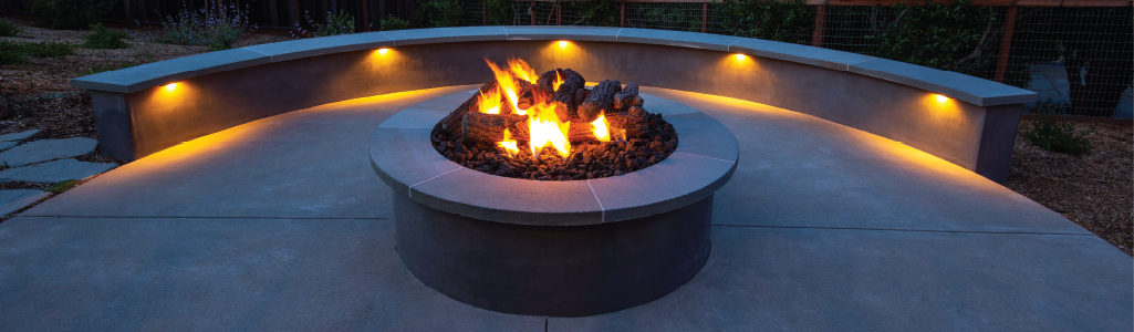 Fire pit with bench lit with wall lights